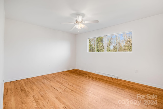 unfurnished room featuring light hardwood / wood-style floors, baseboard heating, and ceiling fan