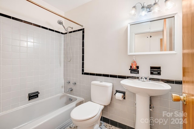 full bathroom featuring sink, tile patterned floors, toilet, tile walls, and tiled shower / bath