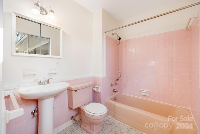 full bathroom featuring tiled shower / bath combo, sink, tile walls, tile patterned flooring, and toilet