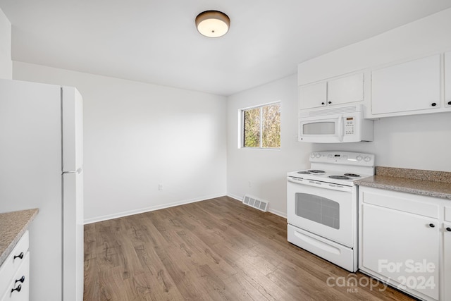 kitchen with white cabinetry, light hardwood / wood-style floors, and white appliances