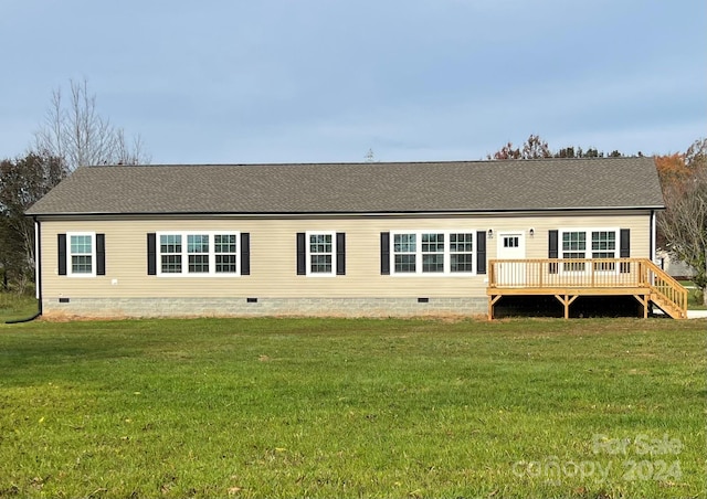 rear view of house featuring a wooden deck and a yard