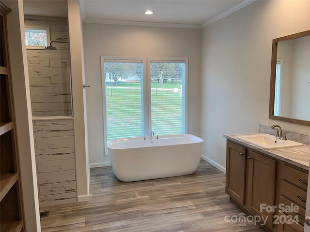 bathroom with a wealth of natural light, hardwood / wood-style floors, and ornamental molding