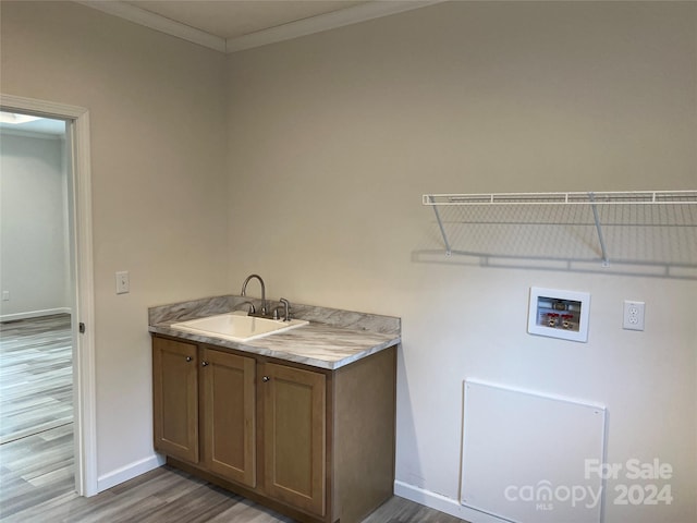 laundry room with crown molding, sink, washer hookup, and wood-type flooring