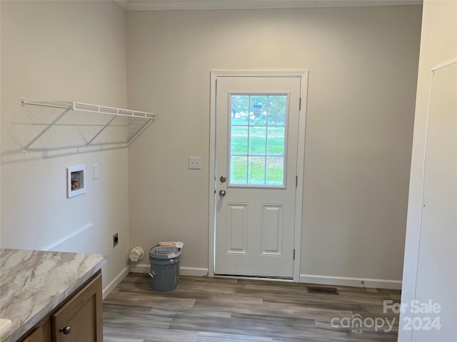 laundry area with electric dryer hookup, cabinets, hookup for a washing machine, and light hardwood / wood-style flooring