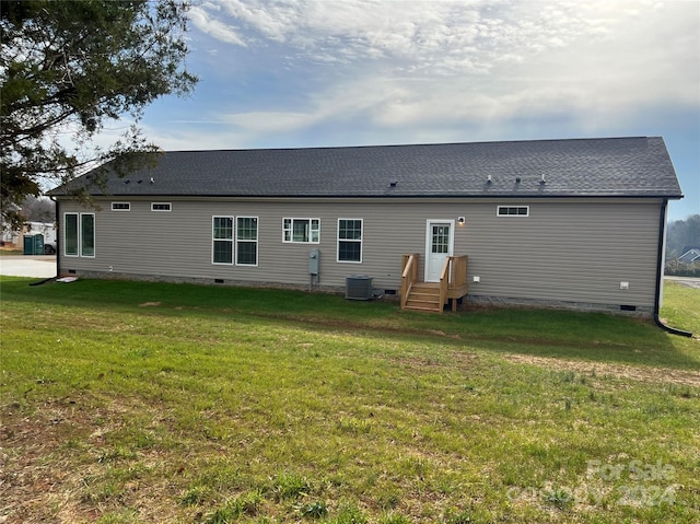 back of property with a lawn and cooling unit