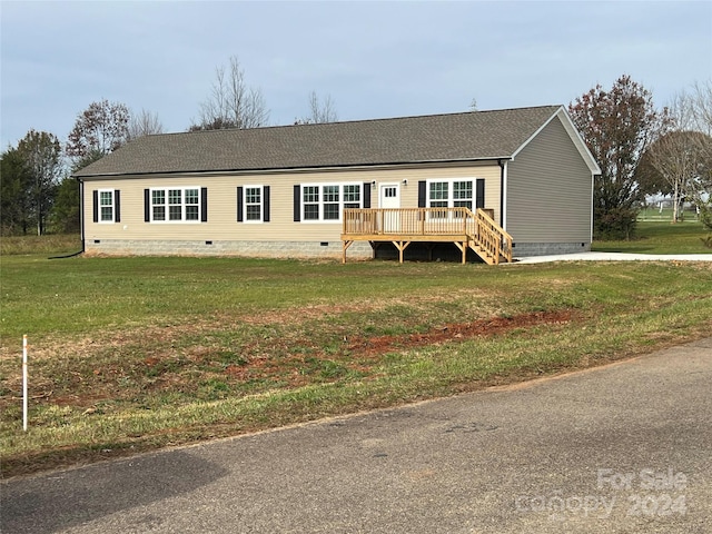 view of front of home with a front yard and a wooden deck