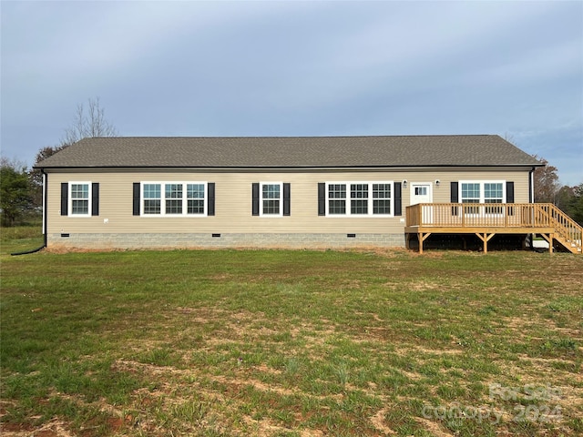 rear view of property with a lawn and a wooden deck