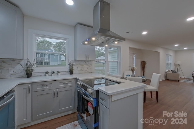 kitchen with decorative backsplash, gray cabinets, island exhaust hood, and stainless steel appliances