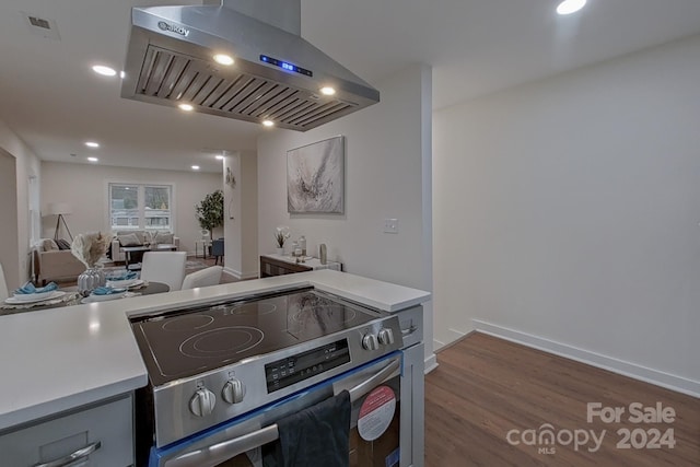 kitchen with island range hood, stainless steel stove, and dark hardwood / wood-style floors