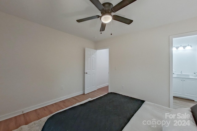 bedroom with ceiling fan, light wood-type flooring, and connected bathroom