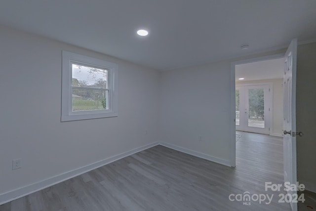 empty room with hardwood / wood-style flooring and a healthy amount of sunlight