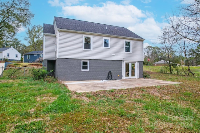 back of property with a lawn, french doors, and a patio