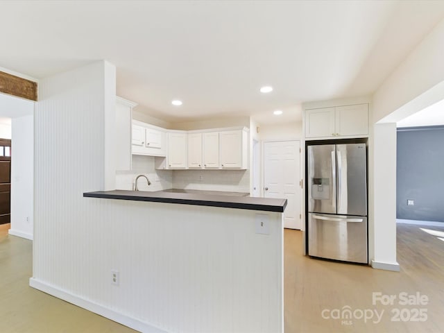 kitchen featuring kitchen peninsula, stainless steel fridge with ice dispenser, and white cabinets