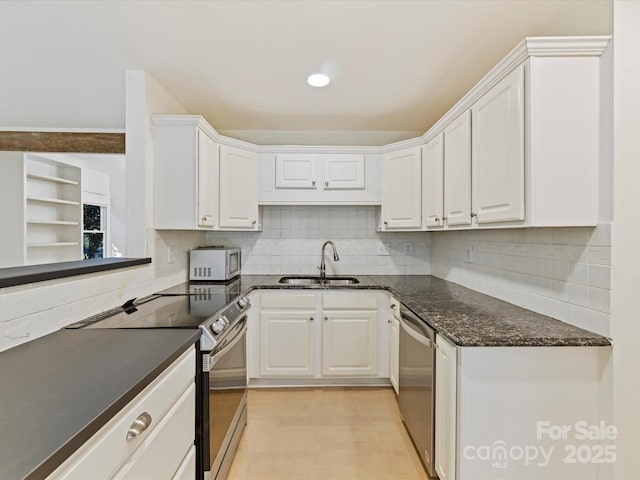 kitchen featuring white cabinetry, sink, backsplash, and stainless steel appliances