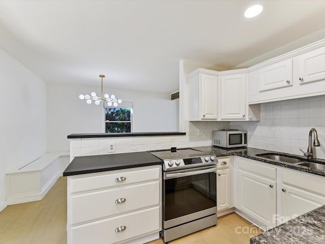 kitchen featuring appliances with stainless steel finishes, kitchen peninsula, sink, and white cabinets