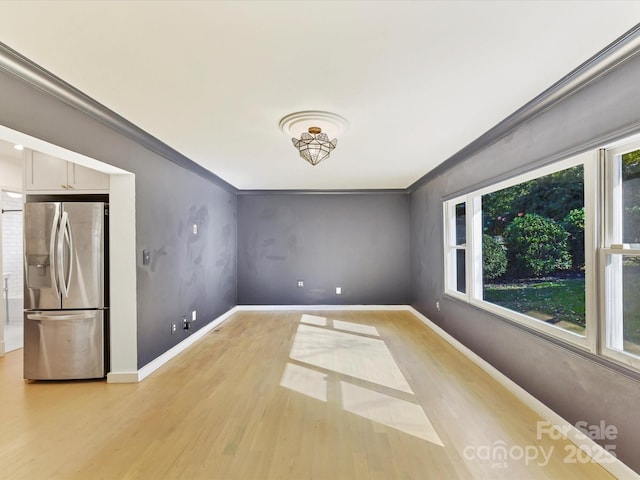 unfurnished room with ornamental molding and light hardwood / wood-style floors