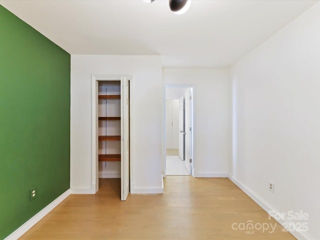 unfurnished bedroom featuring a closet and light hardwood / wood-style flooring