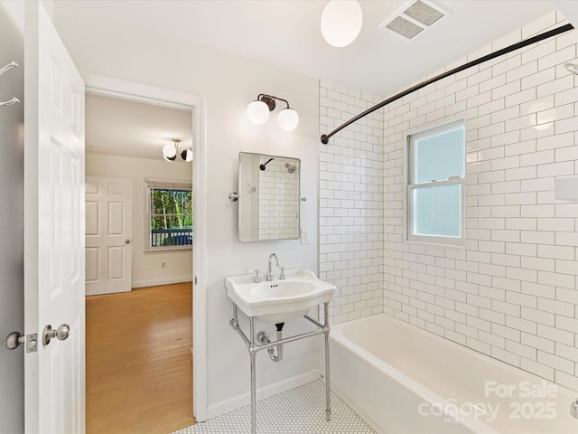 bathroom with tiled shower / bath and wood-type flooring