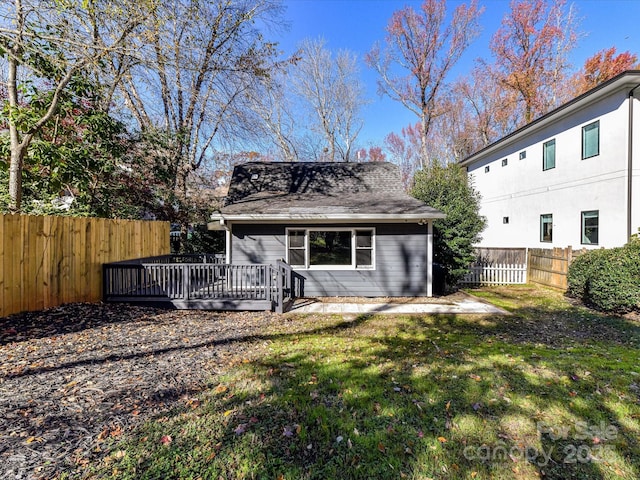 back of house featuring a wooden deck and a lawn