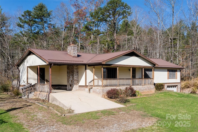 261 Lower Christ School Rd, Fletcher, NC 28732 - view of front facade with covered porch, a chimney, a front lawn, metal roof, and an attached garage