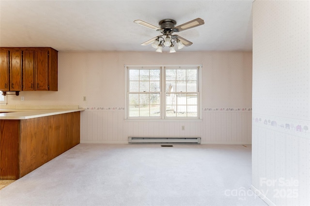 261 Lower Christ School Rd, Fletcher, NC 28732 - kitchen with brown cabinetry, a ceiling fan, a baseboard heating unit, and carpet