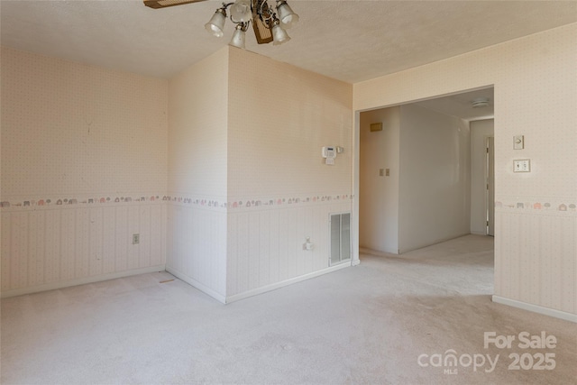 261 Lower Christ School Rd, Fletcher, NC 28732 - spare room with wallpapered walls, carpet flooring, a ceiling fan, a textured ceiling, and baseboards