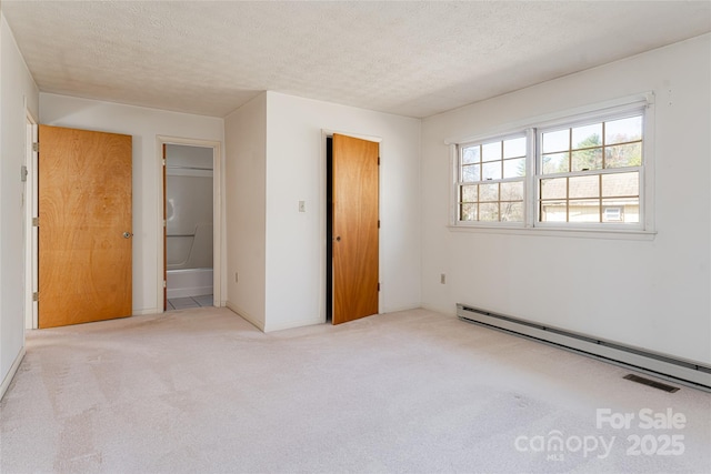 261 Lower Christ School Rd, Fletcher, NC 28732 - unfurnished bedroom featuring a baseboard radiator, carpet floors, a textured ceiling, and connected bathroom