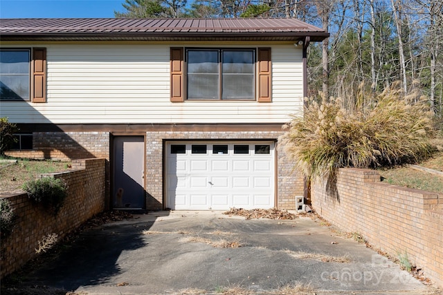 261 Lower Christ School Rd, Fletcher, NC 28732 - view of side of home featuring an attached garage, driveway, metal roof, and brick siding
