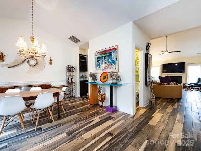 dining space featuring ceiling fan with notable chandelier, dark hardwood / wood-style floors, and a textured ceiling