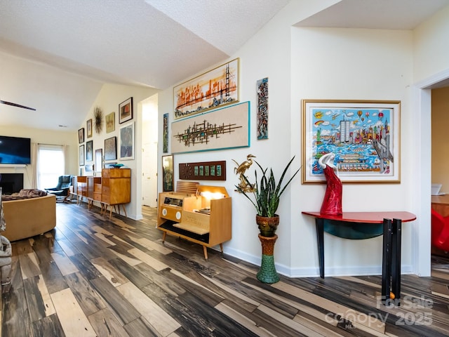 interior space featuring hardwood / wood-style flooring, lofted ceiling, and a textured ceiling