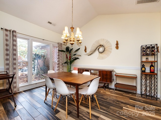 dining area featuring lofted ceiling, dark hardwood / wood-style floors, and a chandelier