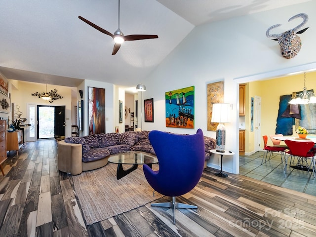 living room featuring wood-type flooring, ceiling fan with notable chandelier, and high vaulted ceiling