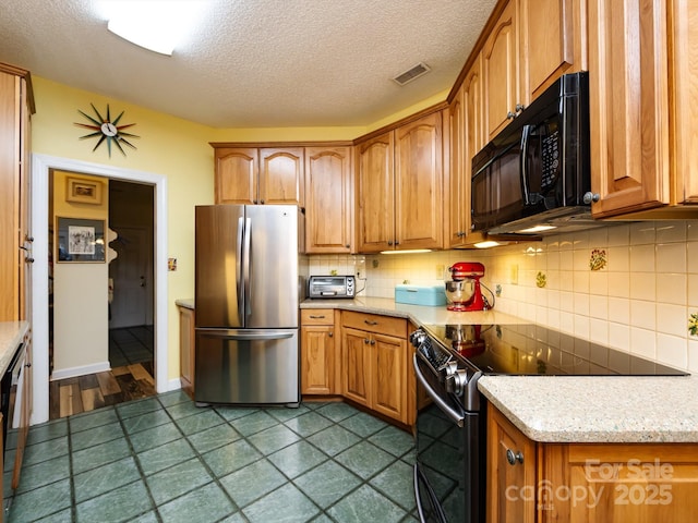 kitchen with stainless steel refrigerator, electric range oven, backsplash, light stone countertops, and a textured ceiling