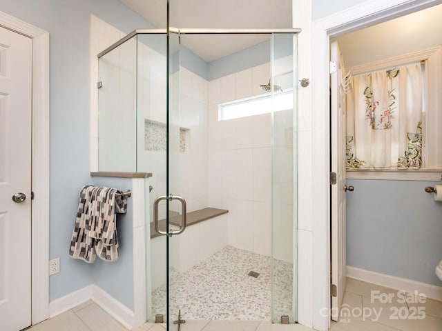 bathroom featuring a shower with door and tile patterned flooring