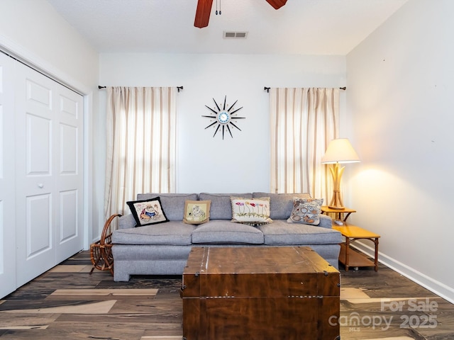 living room featuring ceiling fan and dark hardwood / wood-style flooring