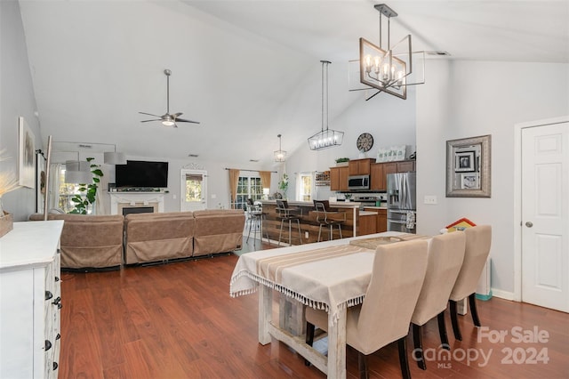 dining space featuring dark hardwood / wood-style floors, high vaulted ceiling, and ceiling fan