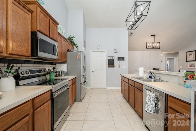 kitchen featuring sink, an inviting chandelier, decorative light fixtures, light tile patterned floors, and appliances with stainless steel finishes