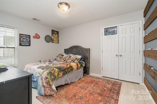 bedroom featuring light wood-type flooring and a closet