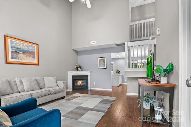 living room with hardwood / wood-style floors and a towering ceiling