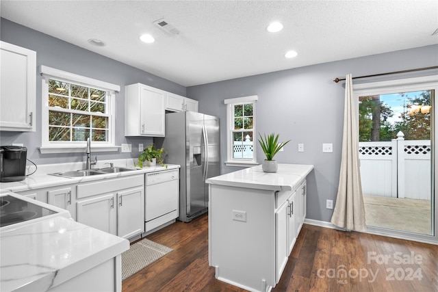 kitchen featuring stainless steel fridge with ice dispenser, white cabinetry, sink, and white dishwasher