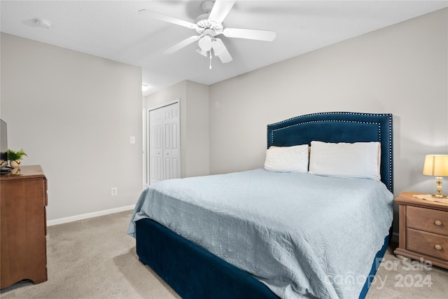 carpeted bedroom with ceiling fan and a closet