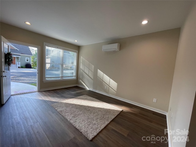 interior space featuring a wall mounted air conditioner and dark wood-type flooring