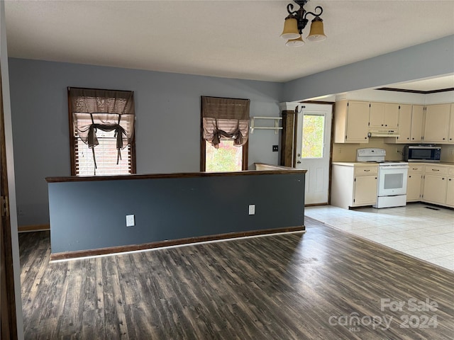 kitchen featuring white electric range oven, cream cabinets, a chandelier, and light hardwood / wood-style flooring