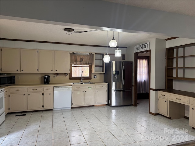 kitchen featuring cream cabinetry, sink, light tile patterned floors, and stainless steel appliances