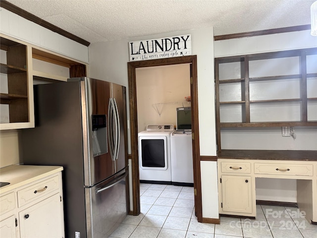 kitchen featuring crown molding, stainless steel fridge, washing machine and dryer, light tile patterned floors, and a textured ceiling