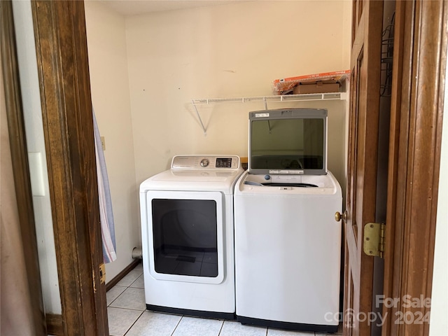 laundry area featuring washer and dryer and light tile patterned flooring