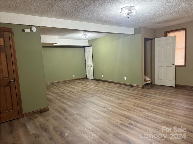 unfurnished room featuring light hardwood / wood-style flooring and a textured ceiling