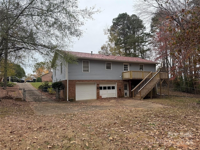 rear view of property with a garage and a deck