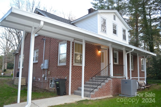 view of front of house with covered porch and central AC unit