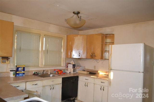 kitchen with dishwasher, white fridge, white cabinetry, and sink